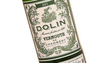 Closeup of a bottle of Dolin dry vermouth with an old-fashioned green and white label.