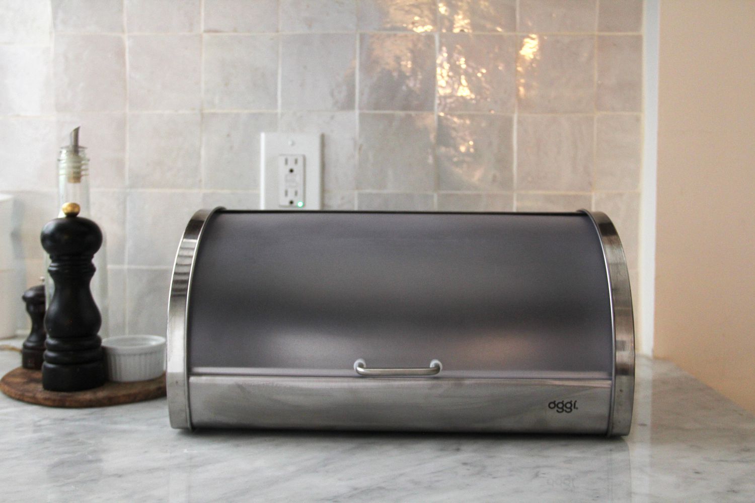 A stainless steel bread box on a kitchen countertop.