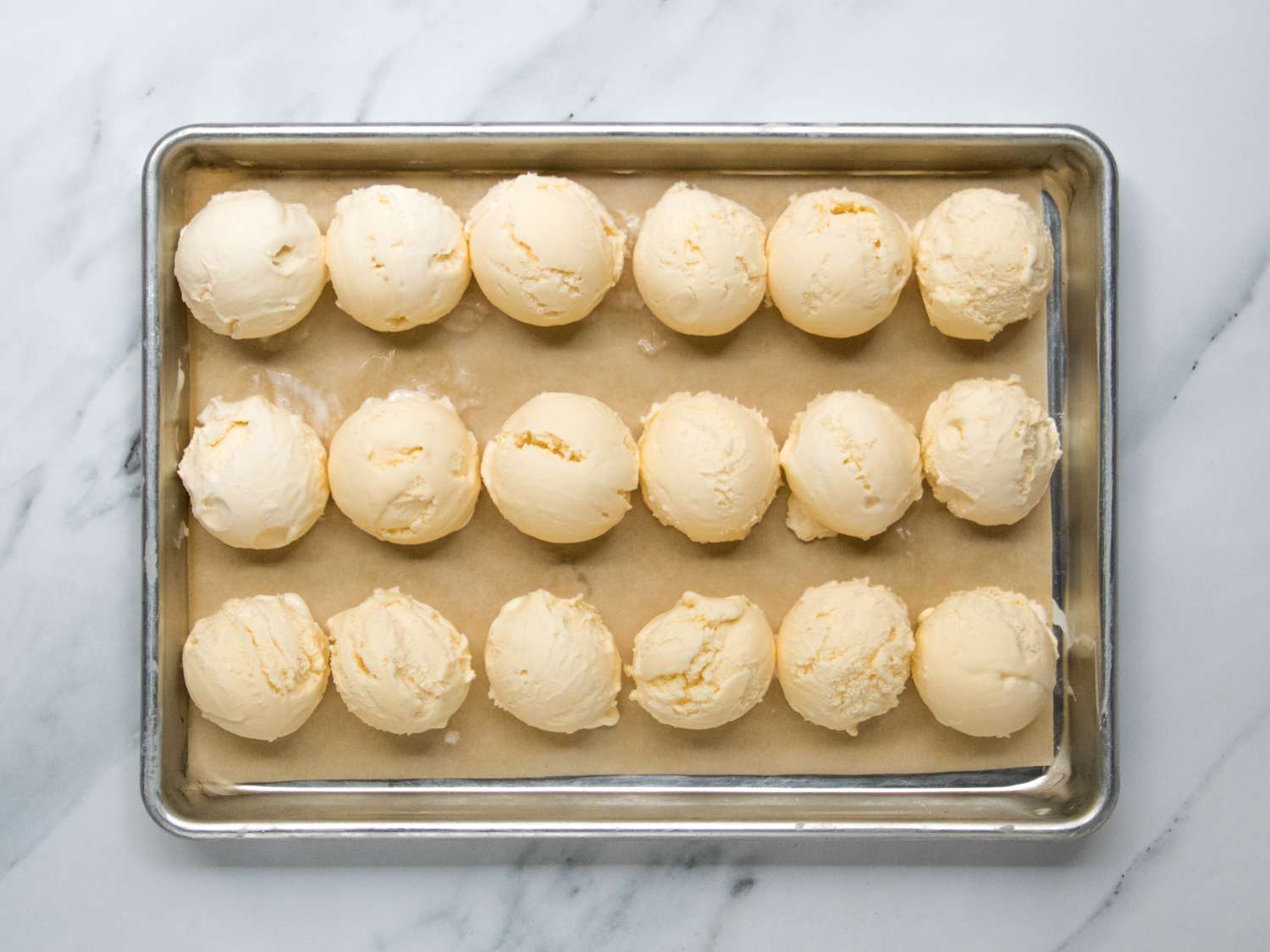 a baking sheet filled with ice cream scoops 