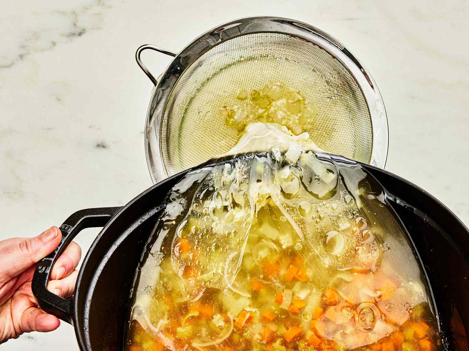 Straining stock through a fine meshed sieve 