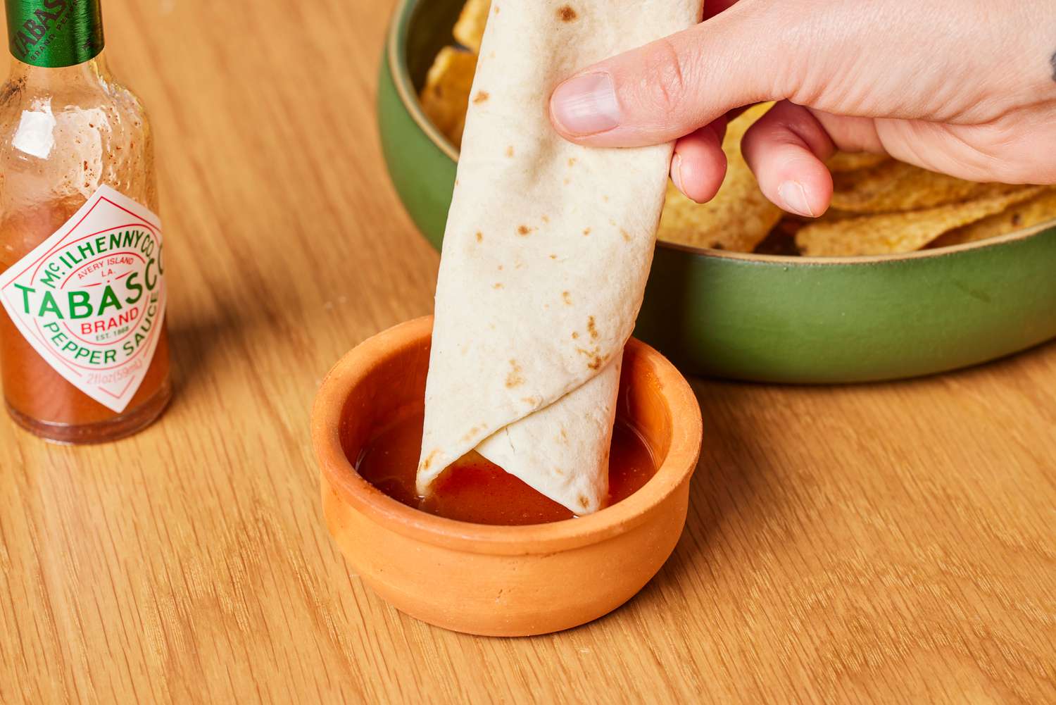 Person dipping tortilla into Tabasco Original Red Sauce