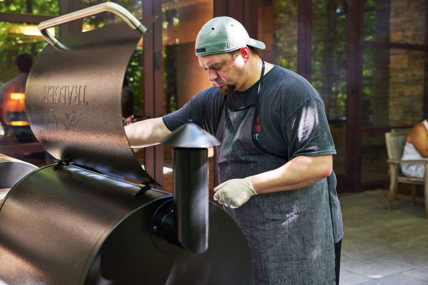 A person looking down at a Traeger grill with its lid open