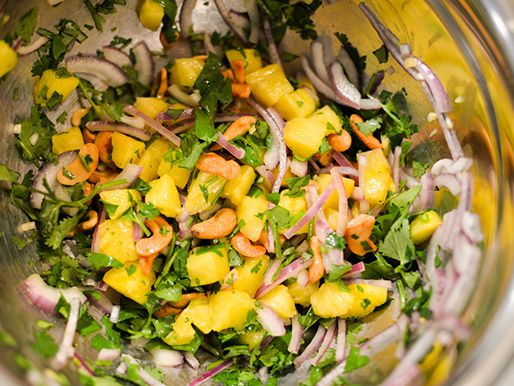 Onion, pineapple, and cilantro are combined in a prep bowl.