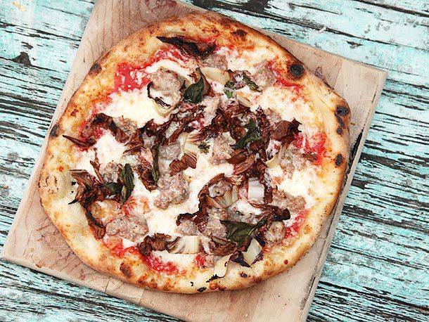 Sausage and radicchio pizza on wooden board