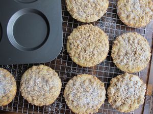 Crumb cake muffin tops on a cooling rack next to a muffin top pan.