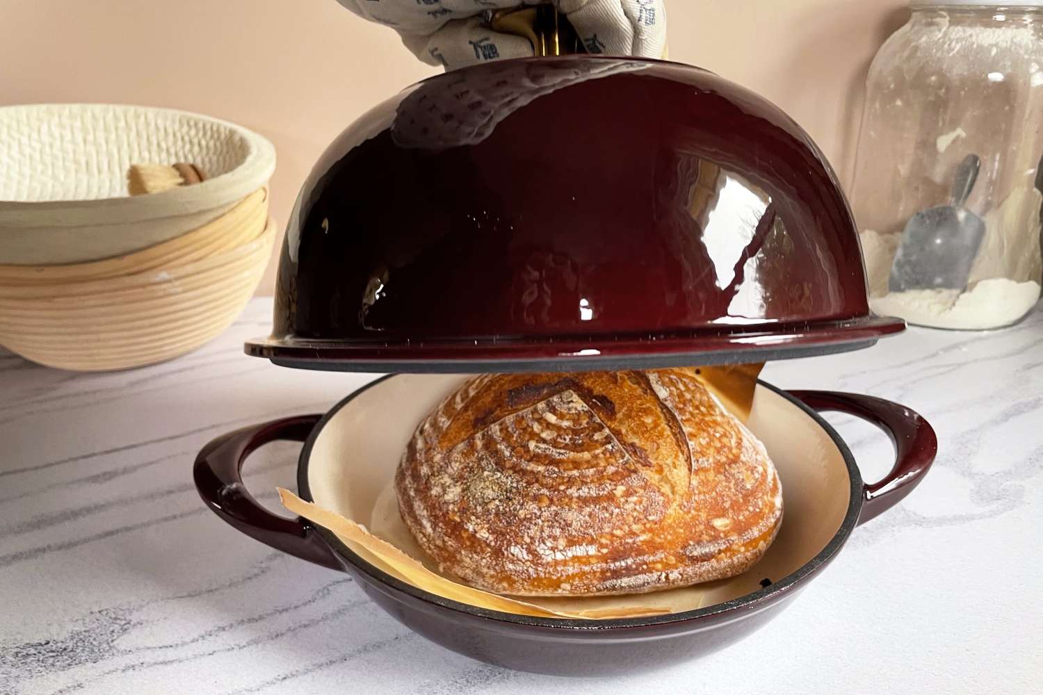 a person lifting the lid from a bread cloche