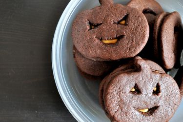 A plate of chocolate peanut butter jack-o-lantern pumpkin cookies.