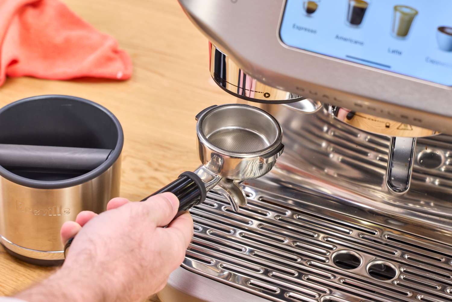 A person adds the portafilter to the Breville The Oracle Dual Boiler Espresso Machine