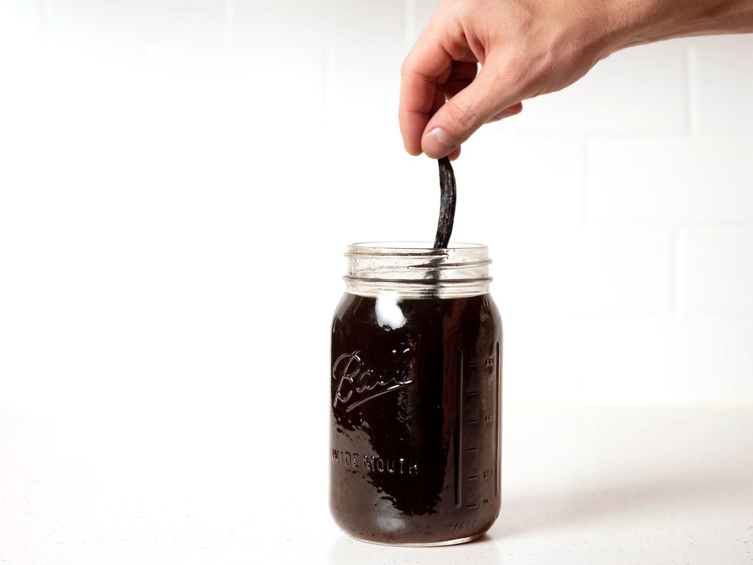 Removing vanilla bean from DIY coffee liqueur after steeping.