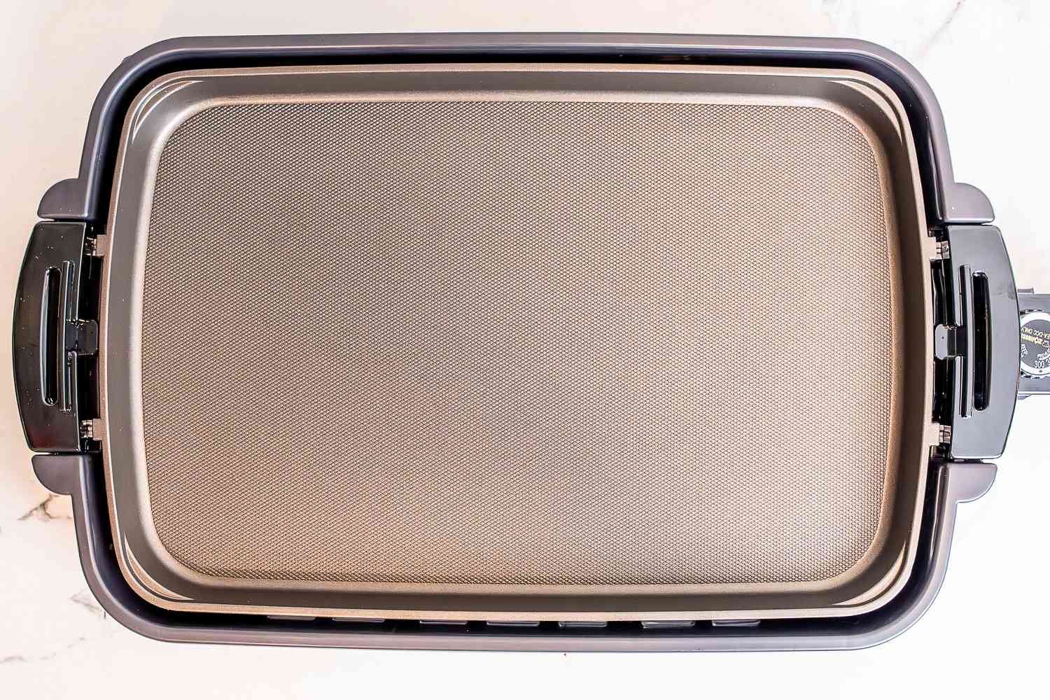 The Zojirushi electric griddle on a white marble countertop