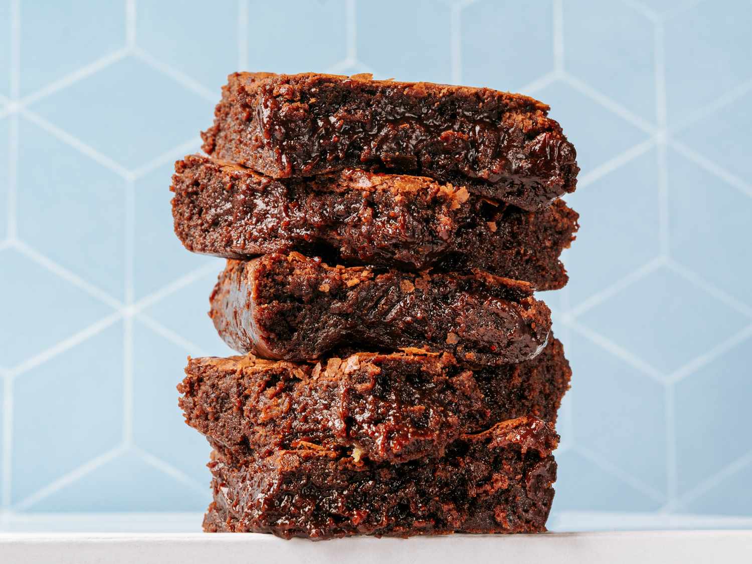 Stacked fudgy brownies with a geometric background