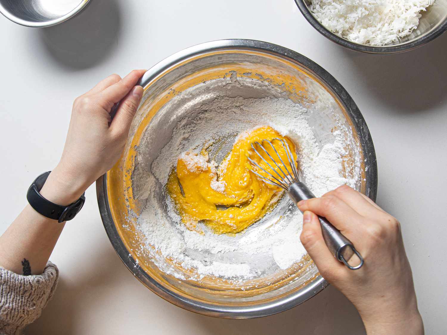Overhead view of whisking eggs into dry material