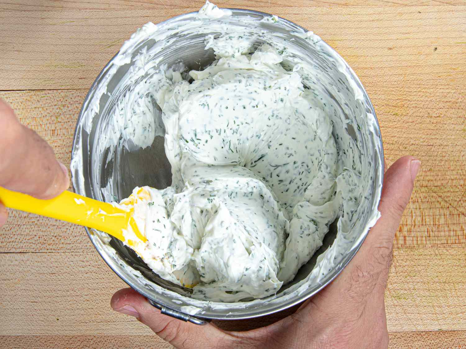 Overhead view of mixing dill cream cheese together