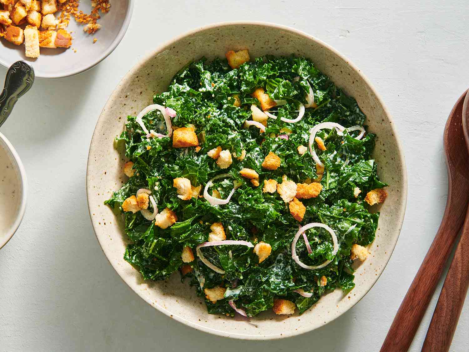 Kale caesar salad in a speckled ceramic bowl