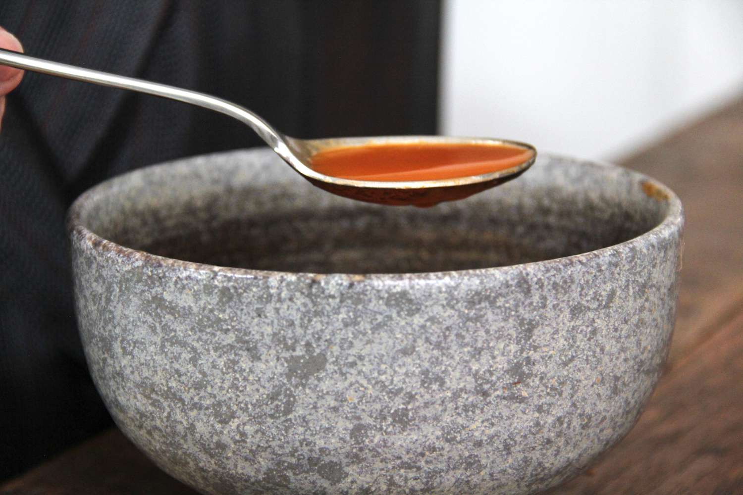 A spoon from the Made In Flatware set with soup in it