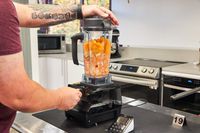 Person blending fruit and vegetables in the Vitamix 5200 Professional-Grade Blender