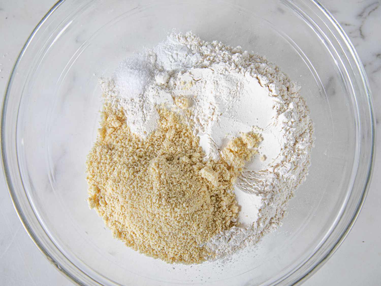 Dry ingredients unmixed in a glass bowl