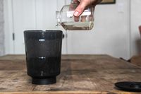 Water being poured on top of coffee grounds in a cold brew maker.