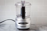 A small Cuisinart food processor on a marble countertop.