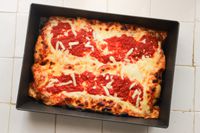 A pizza baked in the LloydPans Kitchenware 10 by 14 Inch Detroit Style Pizza Pan