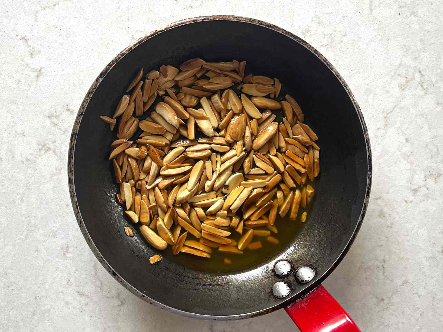 Overhead view of Almonds being toasted in a pan