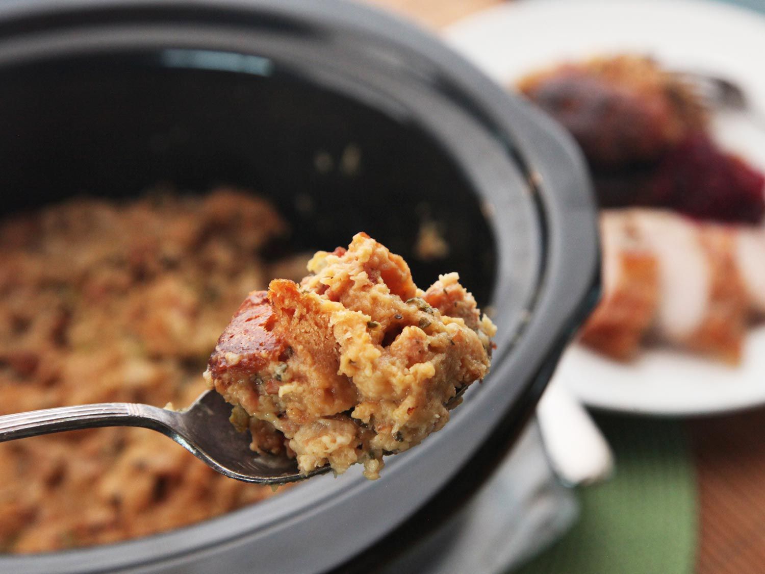 A spoon of crispy golden stuffing taken from the slow cooker. 
