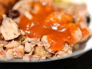 Closeup of barbecue smothered with peach-bourbon barbecue sauce.