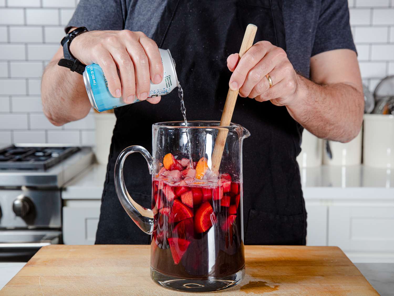 Author stirring club soda into a pitcher of sangria.