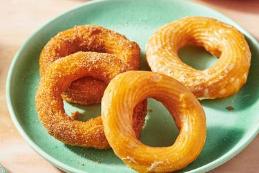 A plate with four cruller doughnuts
