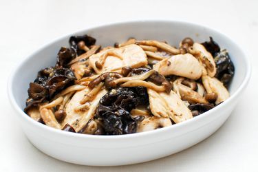 Stir-fried chicken with mushrooms and oyster sauce, served in an oblong white bowl.