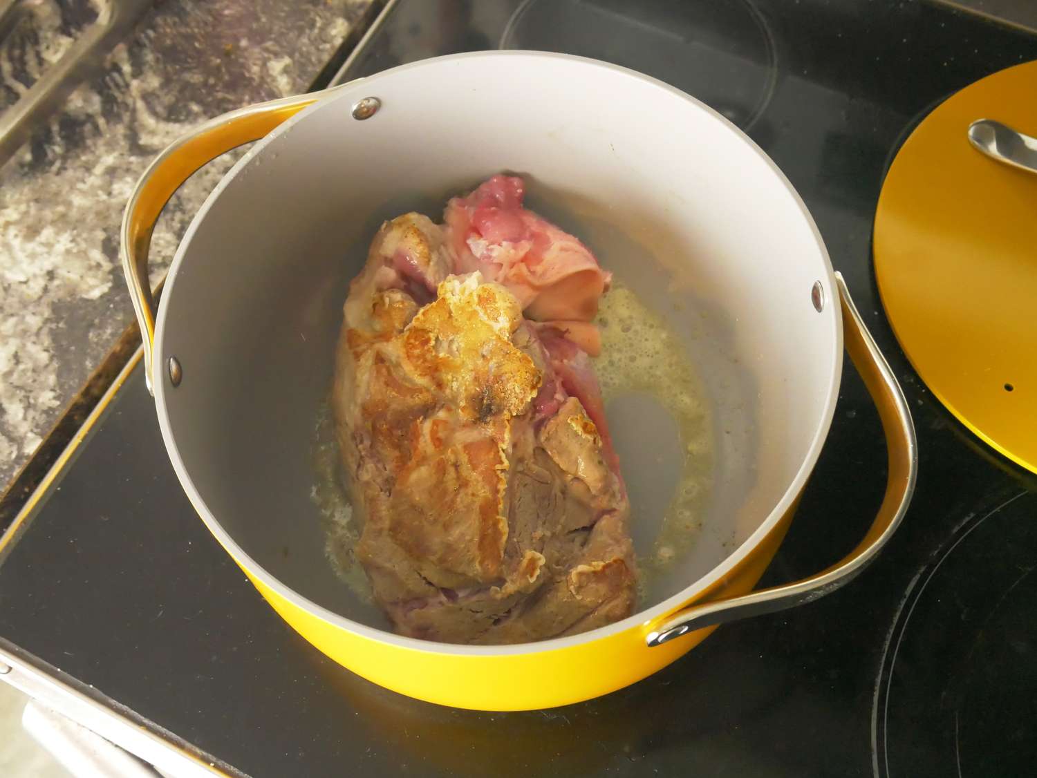 a piece of pork seared in a dutch oven
