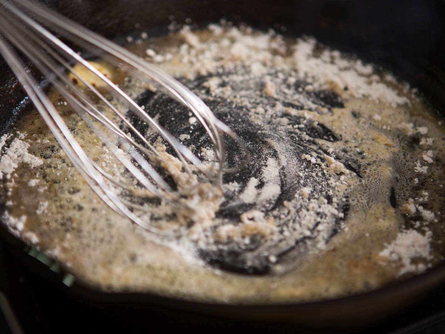 Whisking flour into melted butter to make gravy for Maryland fried chicken. 
