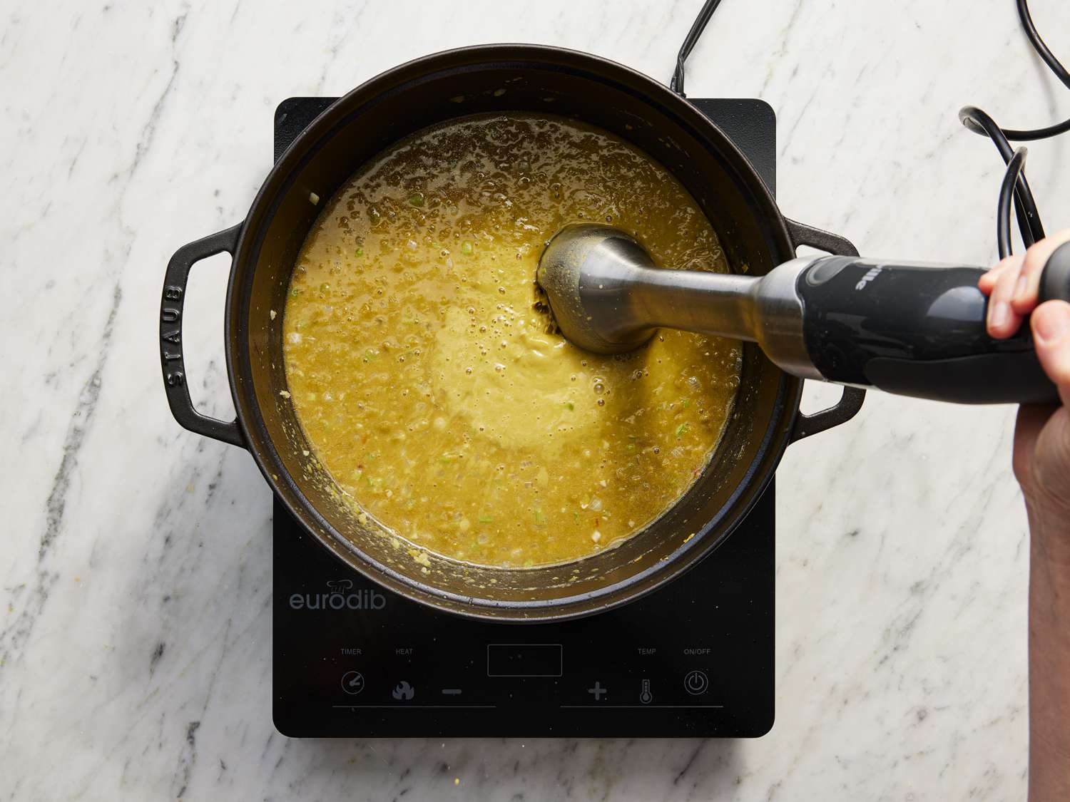 Blending the soup with an immersion blender