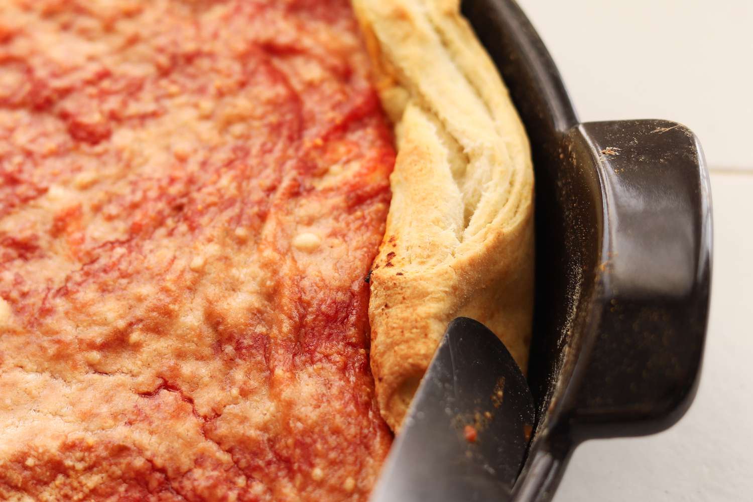 Checking the stickiness and edge of the pizza using the Emile Henry Deep Dish Pizza Pan