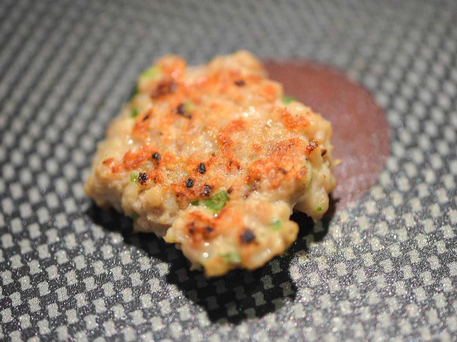 A small test patty of the tsukune mixture is cooked in a nonstick skillet.