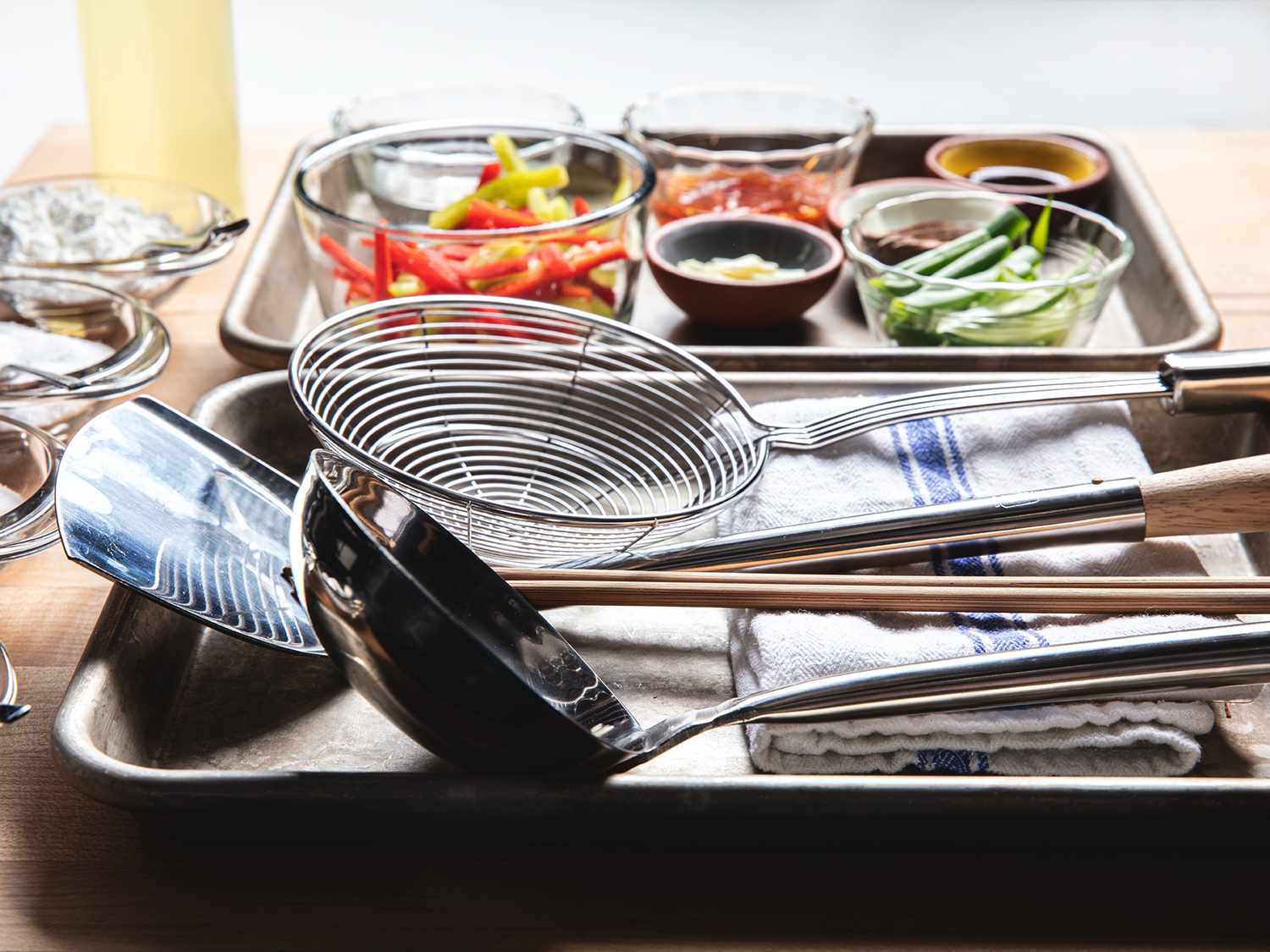Side angle view of tools and mise en place of a wok station set up