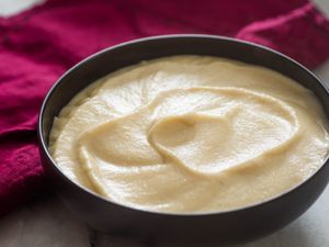 A dark bowl of smooth and silky cauliflower puree. 