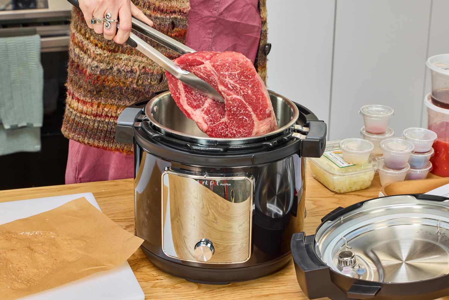 A person places meat into the Instant Pot Pro Plus Wi-Fi Smart 10-in-1 6-Quart Pressure Cooker