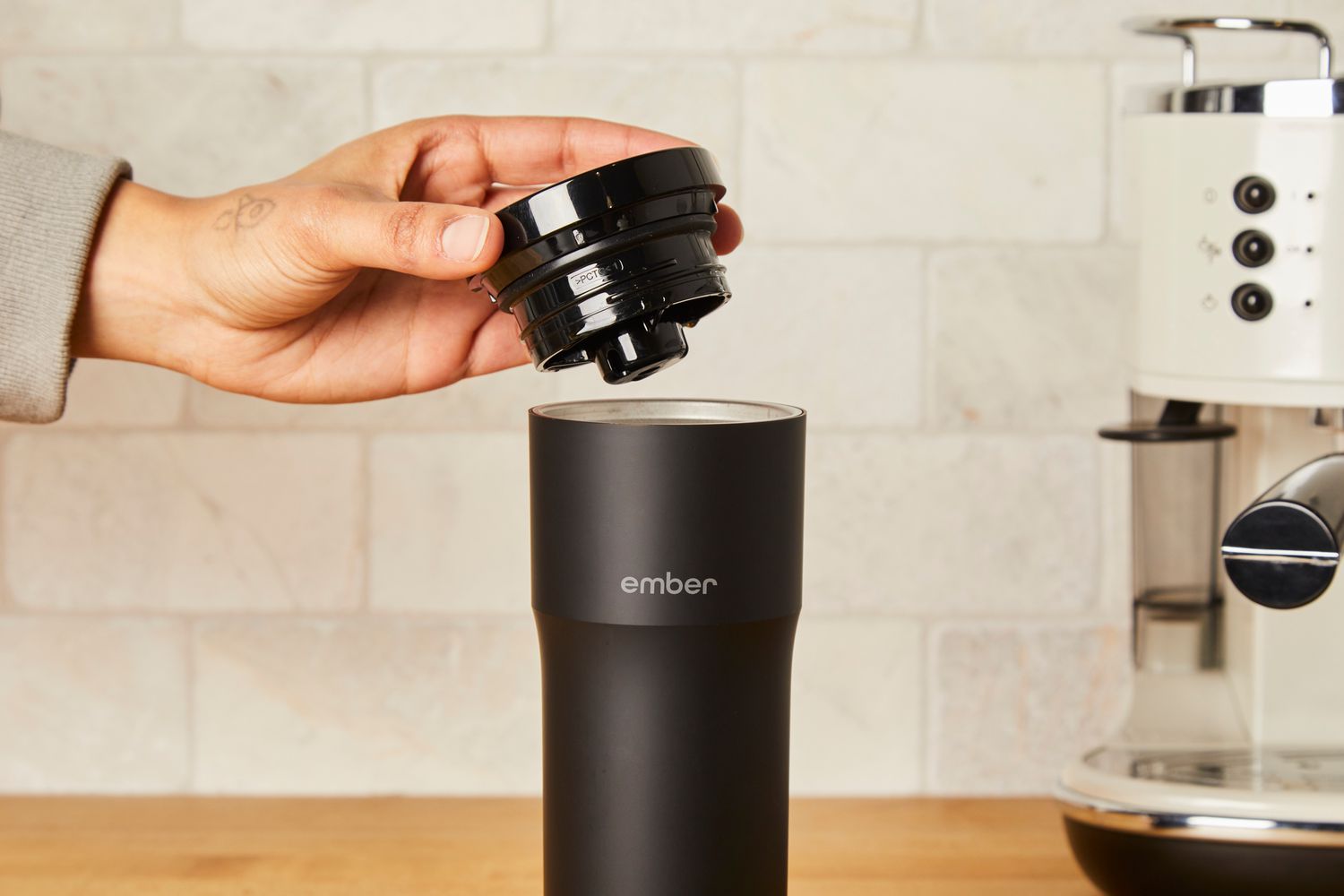 Person putting lid on Ember Travel Mug 2