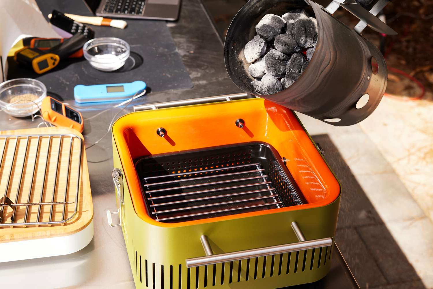 Pouring charcoal into Everdure CUBE Portable Charcoal Grill 