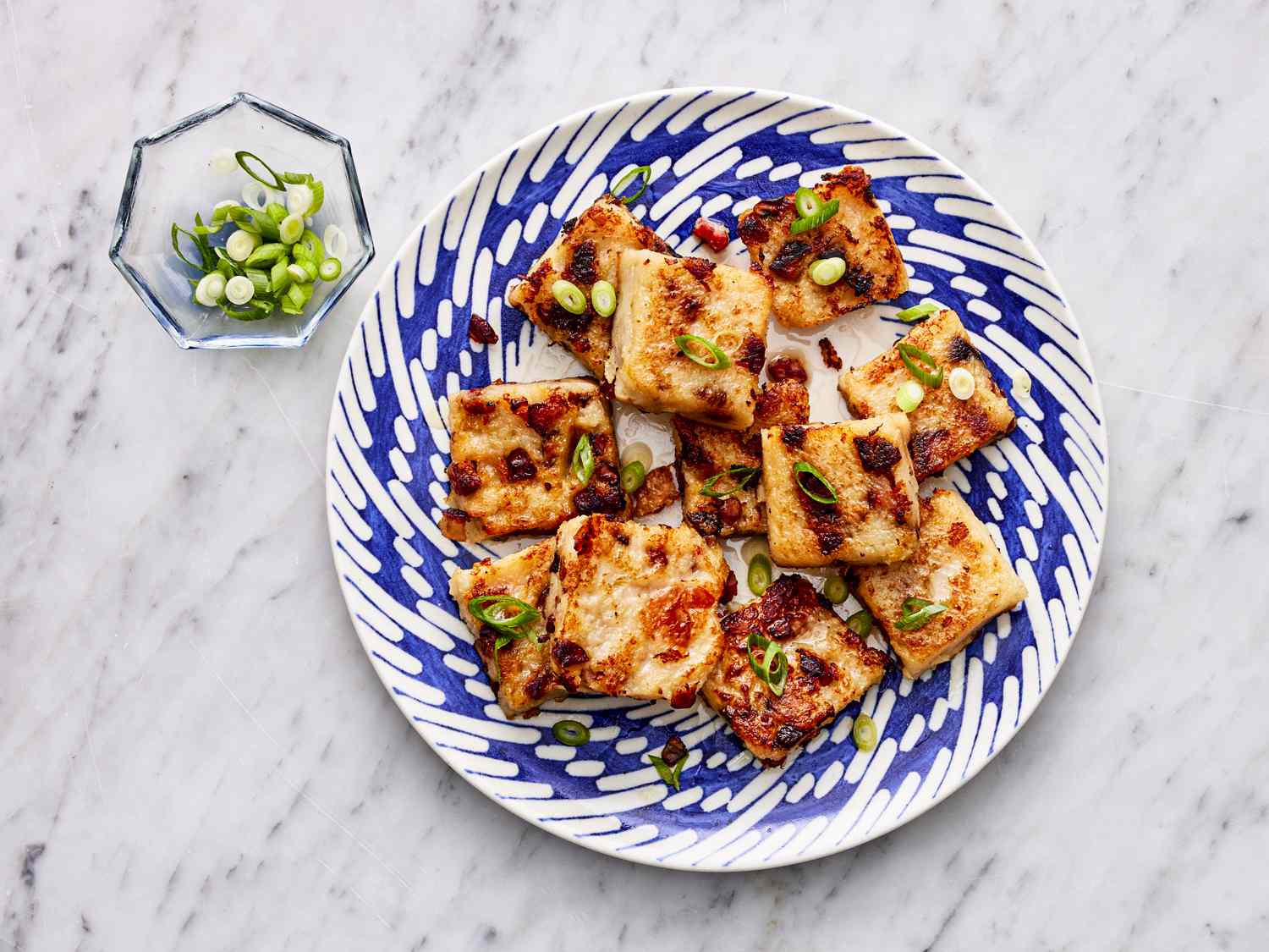 Overhead view of finished turnip cake on a blue patterned plate 