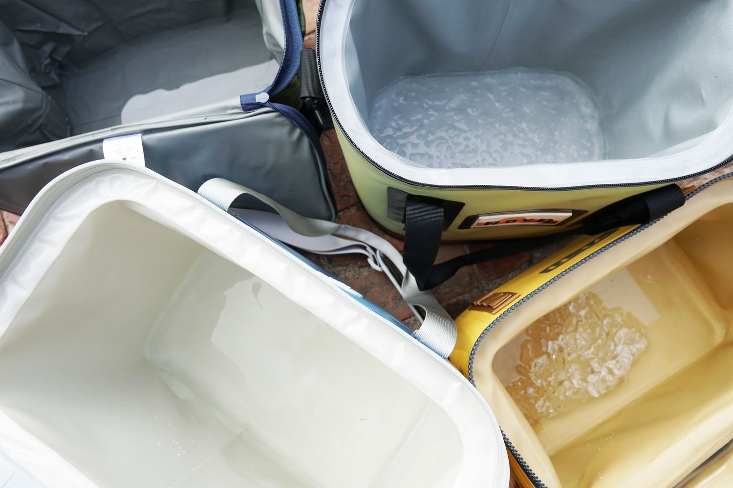 four soft coolers: two with ice in them and two without ice