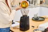 A person pours coffee beans into the Baratza ZCG495 Encore ESP Coffee Grinder