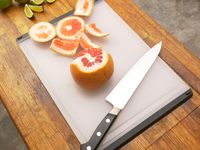 the oxo plastic cutting board with a grapefruit on it