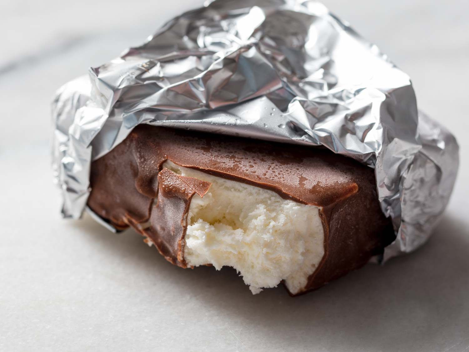 Close up of a homemade Klondike bar with a bite taken out of it. 