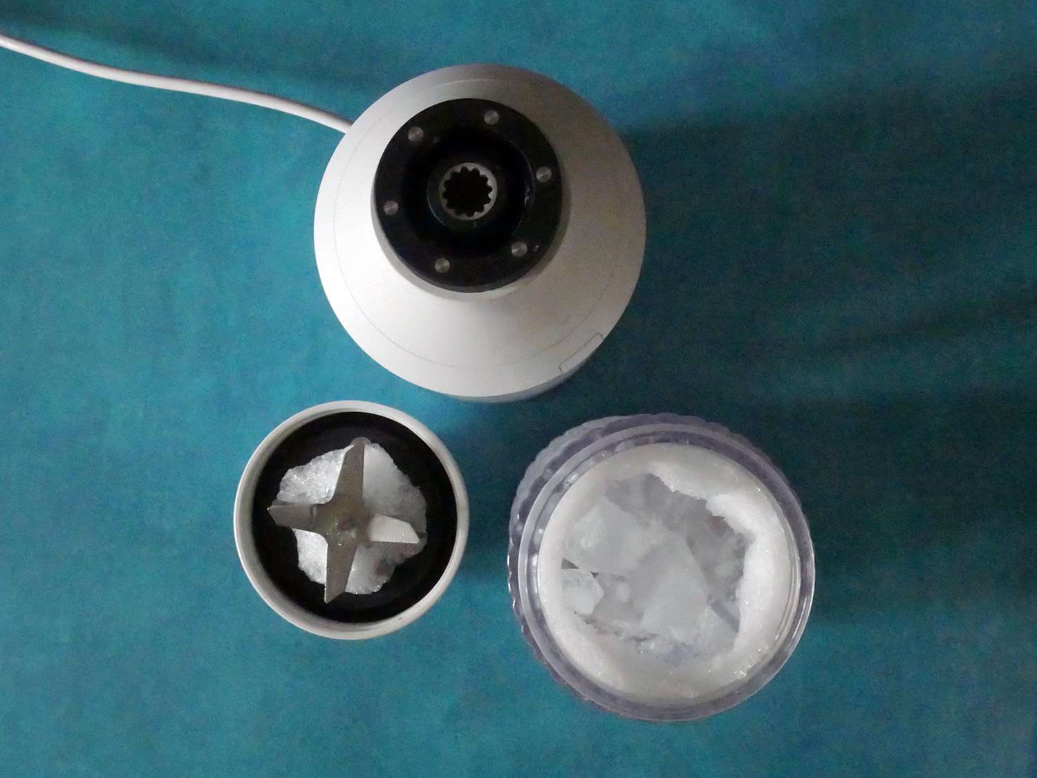 the beast blender taken apart with an overhead shot into the jar and the chunks of ice inside. 