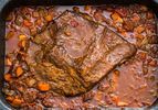 Overhead shot of a Jewish-style braised brisket in a sauce of carrots and onions