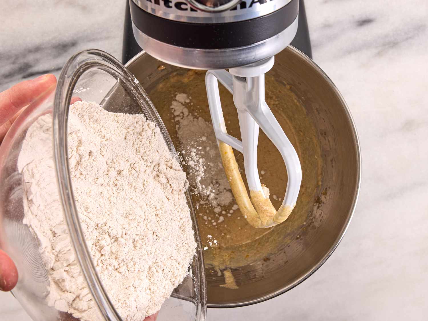 adding flour to mixing stand with batter