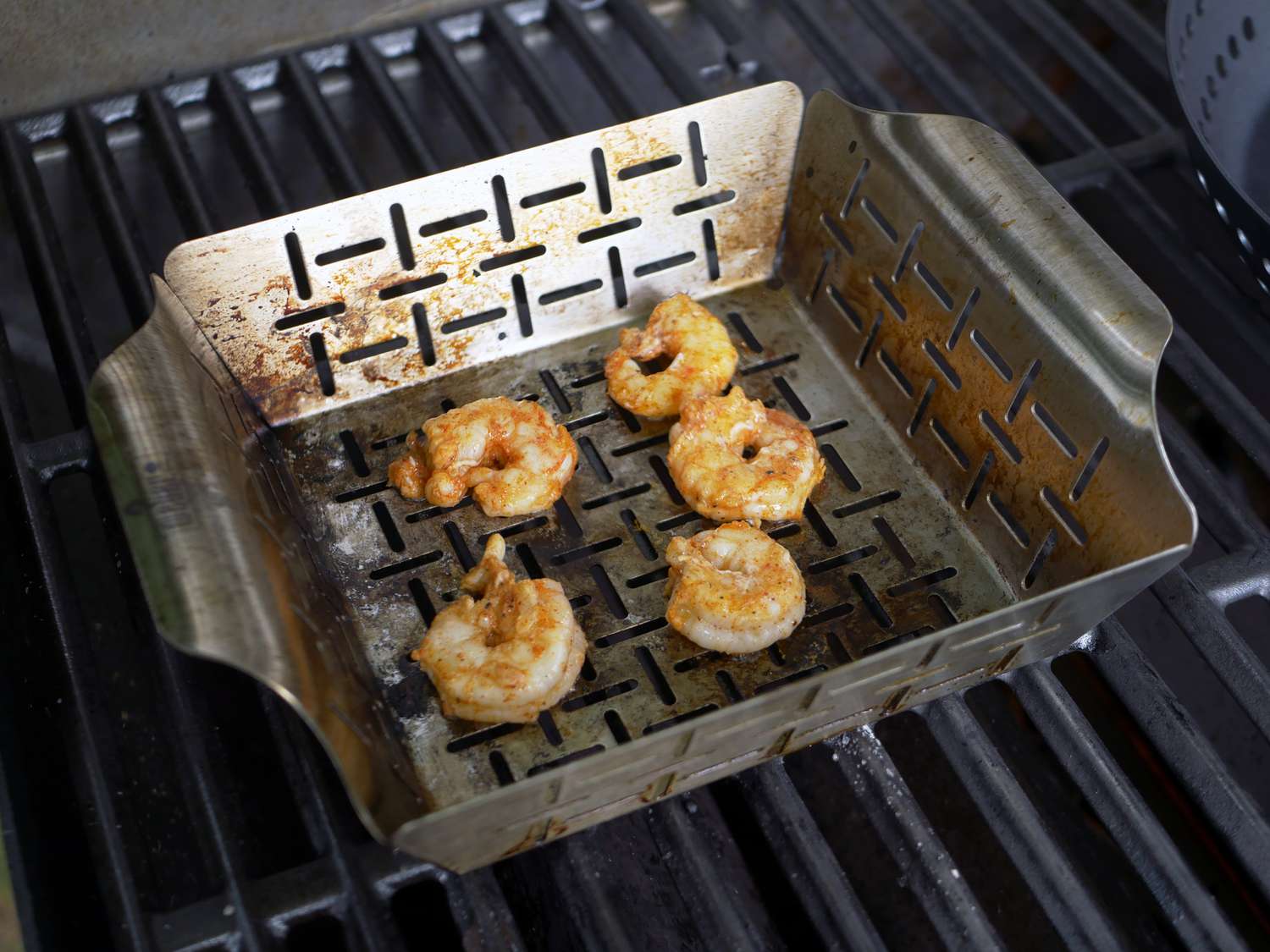 a few shrimp in a pan-style grill basket