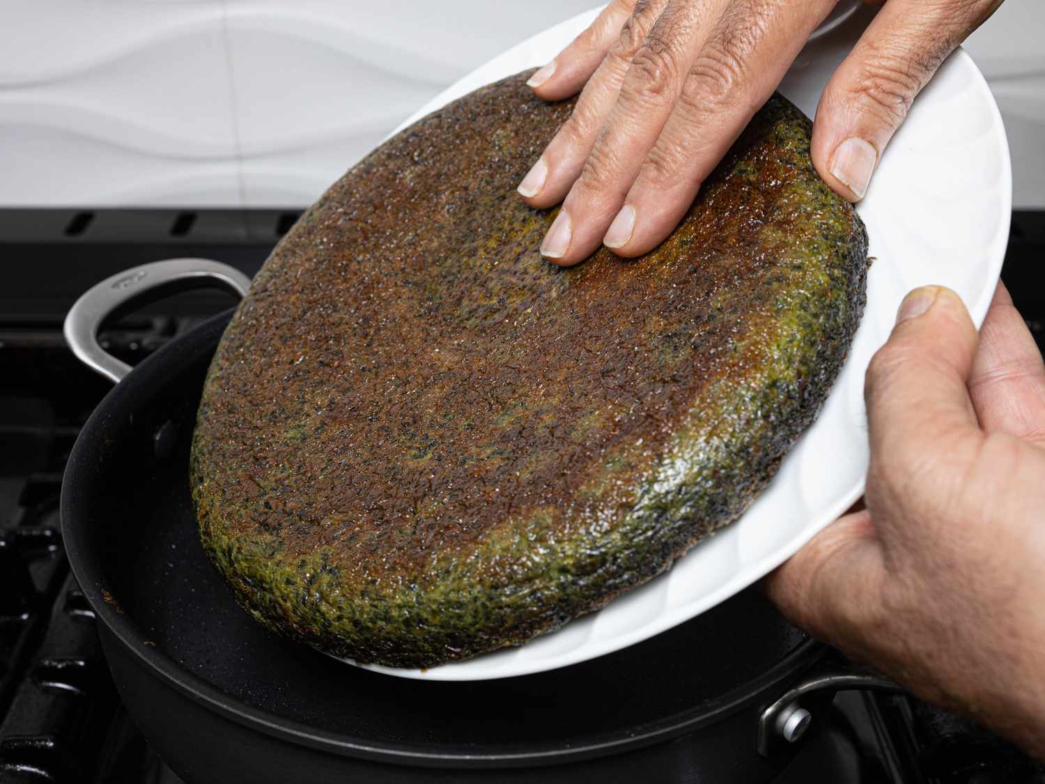 Flipped Kookoo sliding back onto freshly buttered skillet 